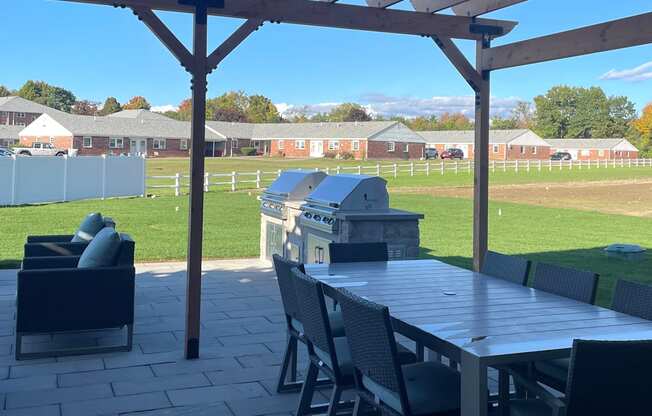 a patio with a table and chairs and a grill