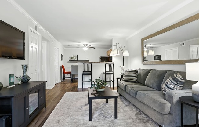 A living room with a grey couch and a wooden coffee table.