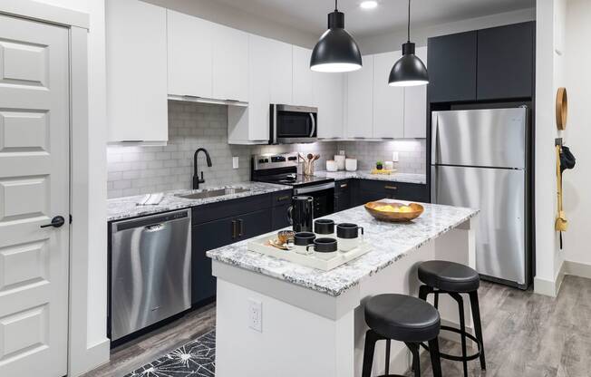 a kitchen with a large island and stainless steel appliances