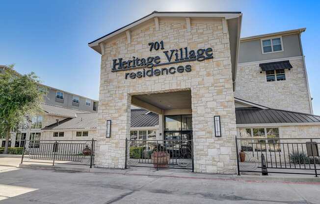 the facade of heritage village residences with a gate