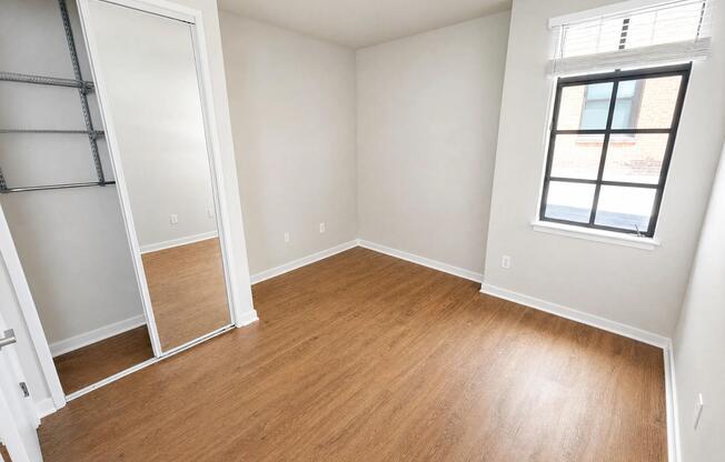 Redesigned bedroom with a mirrored closet and oversized window.