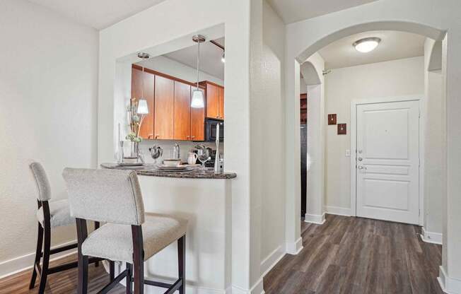 A kitchen with a table and chairs.