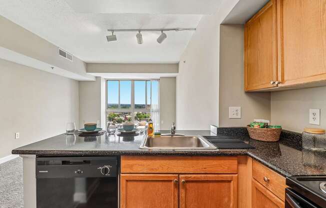 A kitchen with wooden cabinets and a black countertop.