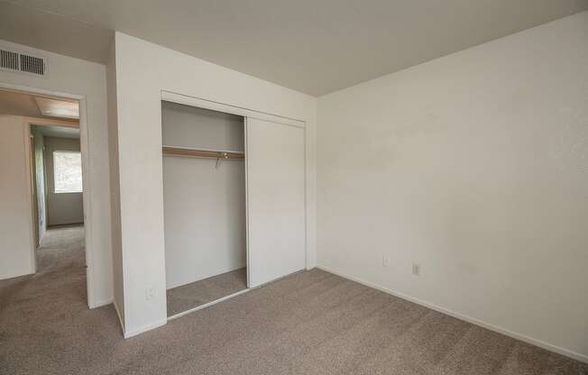 A room with a carpeted floor and a white wall with a doorway leading to another room at Pepperwood Apartments, California, 95661