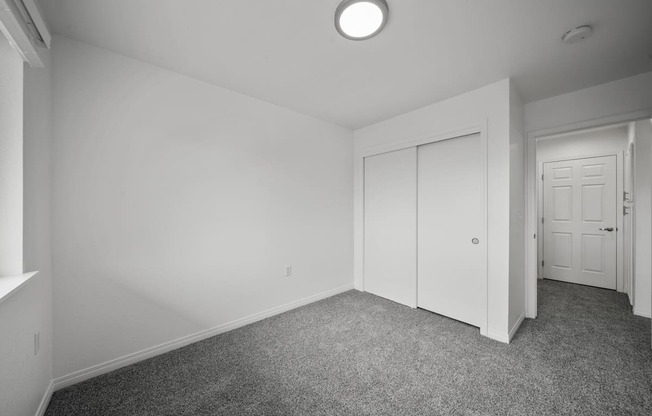 a bedroom with white walls and carpet