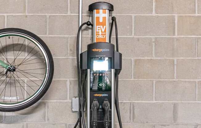 A bicycle is parked next to a charging station.