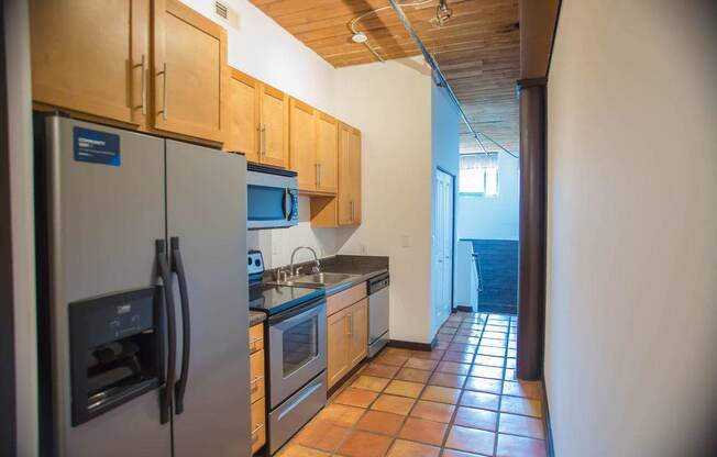 A kitchen with a refrigerator, oven, and microwave.