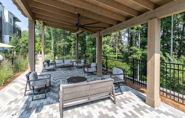 a covered patio with couches and chairs at Century University City, Charlotte, 28213