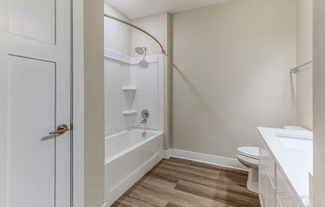 A white bathroom with a toilet, sink, and bathtub.