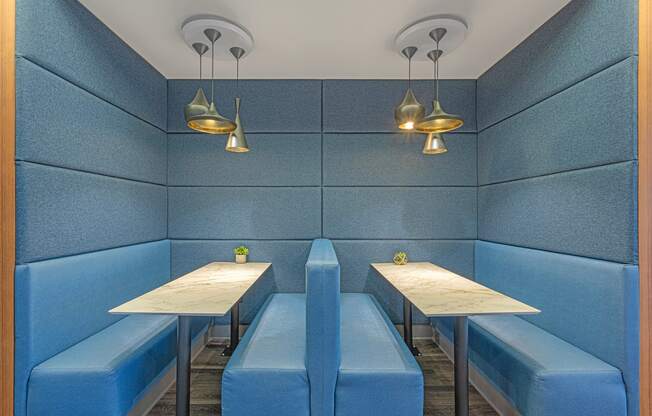 two tables and two benches in a blue booth