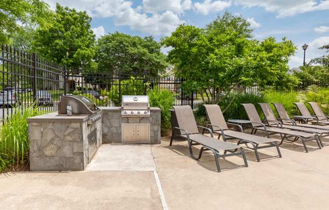 Sundeck with lounge chairs, and stone outdoor grilling area
