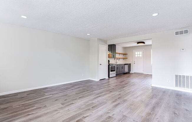 a spacious living room with a kitchen in the background  at The Oasis on Cascade, Atlanta, 30310