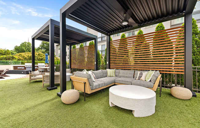 A modern outdoor seating area with a wooden bench and a white cushion.