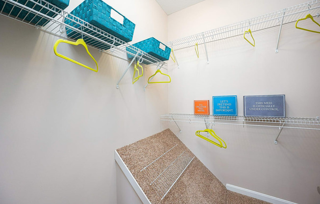 an empty closet with baskets and hooks on the wall