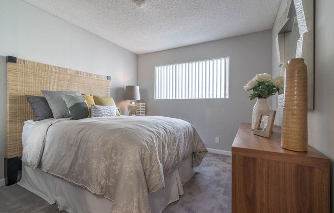 a bedroom with a bed and a dresser and a window at Sunnyvale Crossings Apartments, LLC, California