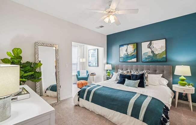 A bedroom with a large bed and a ceiling fan.