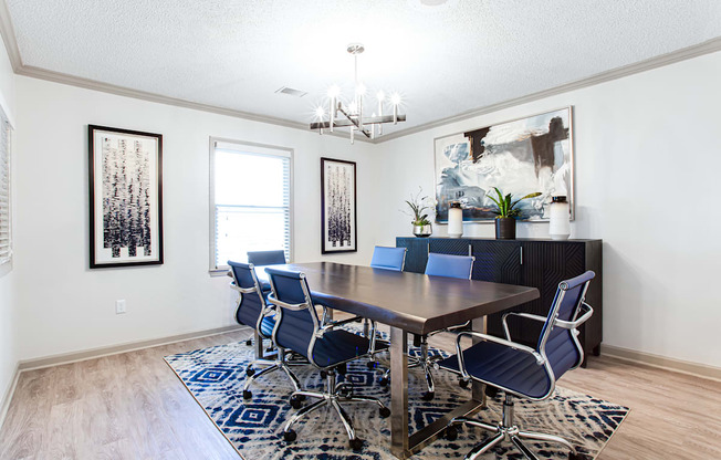 a dining room with a table and chairs and a chandelier  at Barcelo at East Cobb, Marietta