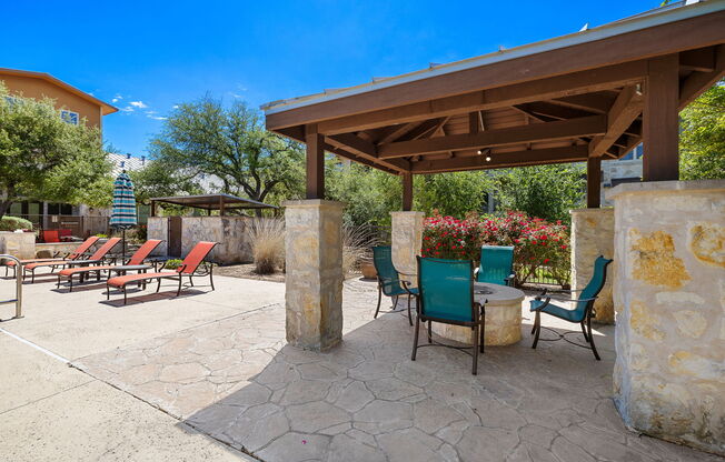 a patio with a table and chairs under a pavilion at Lakeline East Apartments, Cedar Park