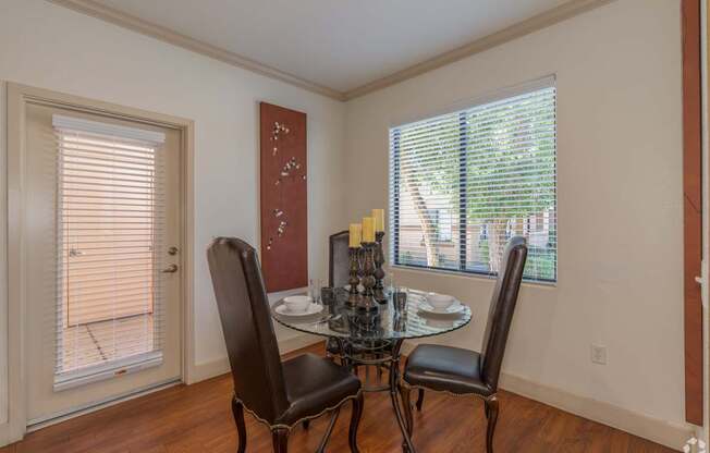A dining room with a table and chairs.