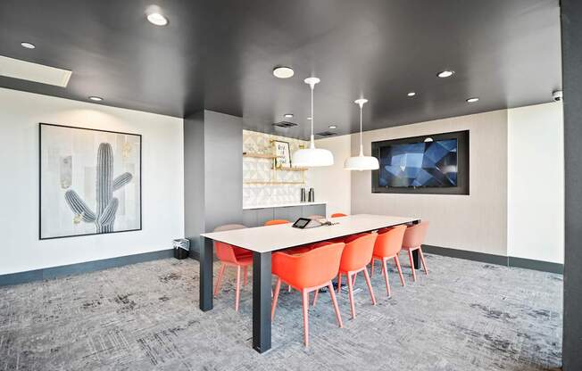 A conference room with a long table and chairs.