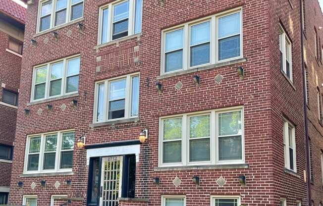 A red brick building with a black door and windows.