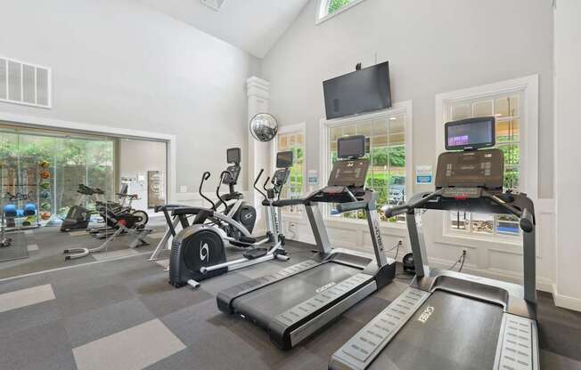A gym with treadmills, exercise bikes, and other equipment.