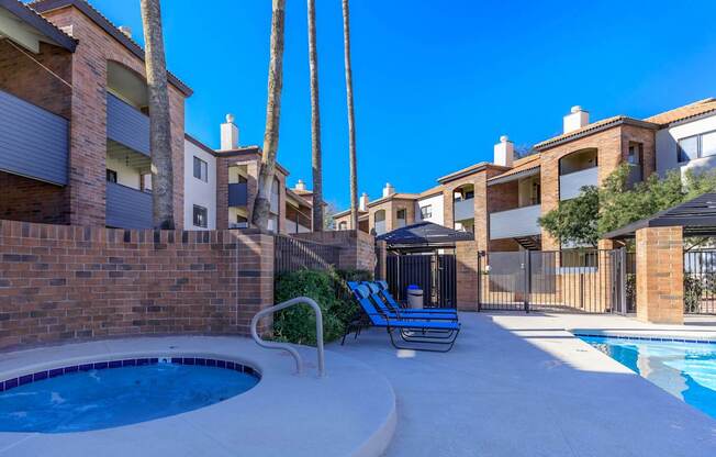 A pool surrounded by a brick wall and palm trees.