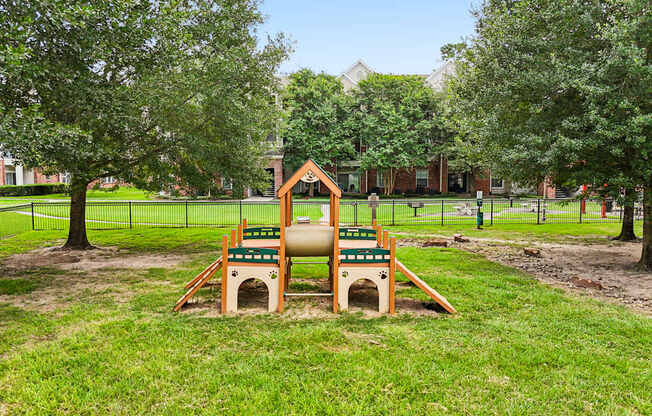 A playground with a slide and a sandbox in the foreground.