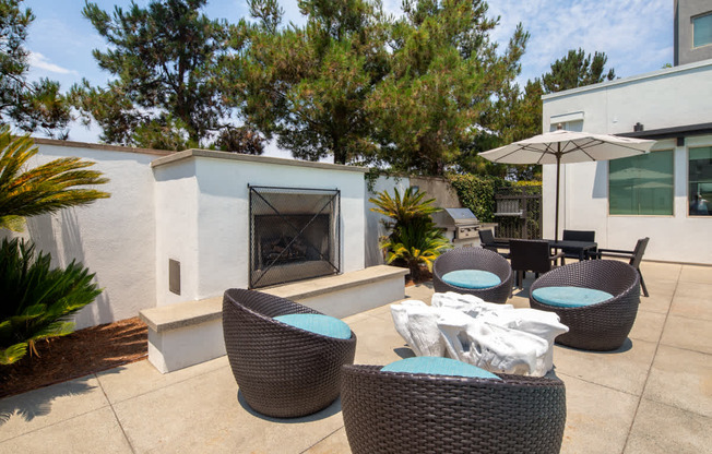 A patio with a fireplace and chairs.
