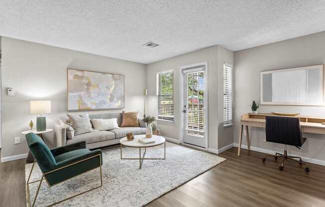 A living room with a green chair and a white couch.