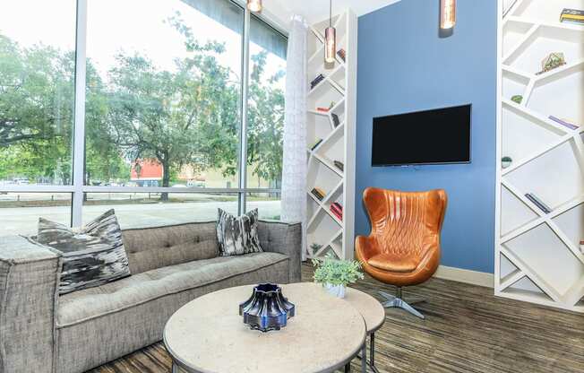 a living room with a couch and a table    and a large window