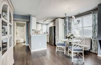 A kitchen with a table and chairs.