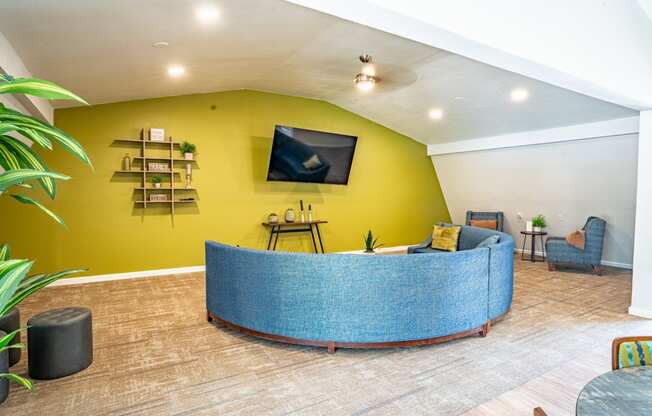 a reception area with a yellow wall and blue furniture