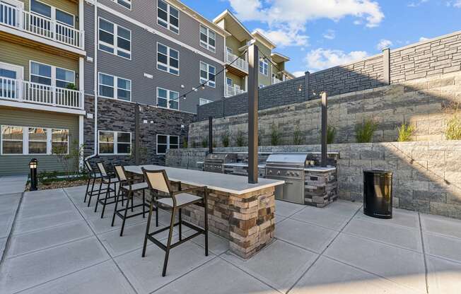 an outdoor patio with a grill and a table with chairs
