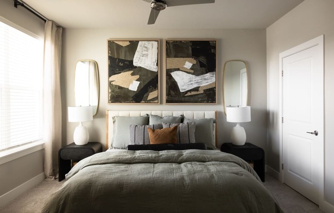 a bedroom with a bed and two paintings on the wall