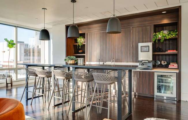 A modern kitchen with a bar area and chairs.
