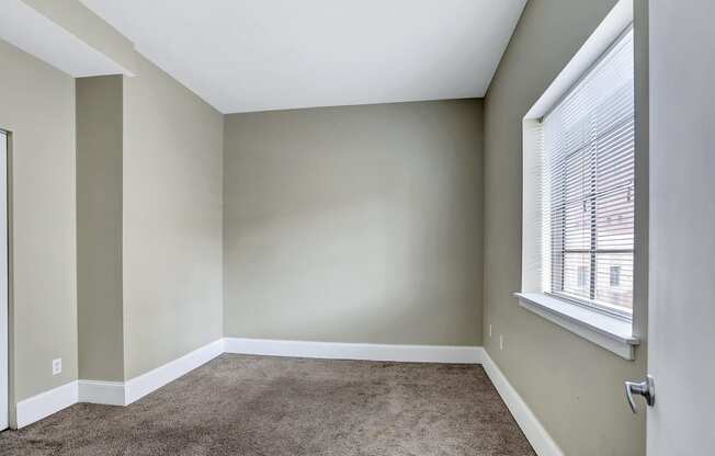 an empty room with carpet and a window