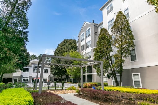 an exterior view of an apartment building with trees and a sidewalk at Willowest in Lindbergh, Atlanta, GA, 30318