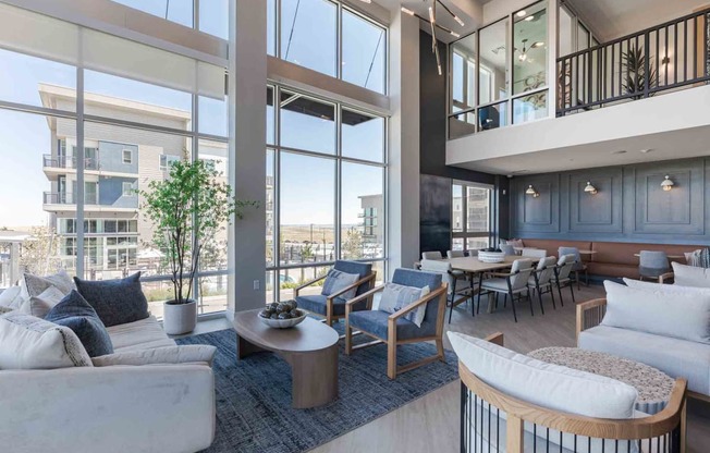 a living room with couches and a table with chairs and a balcony