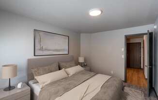 a bedroom with a bed and a door to the hallway. Fargo, ND Granger Court Apartments