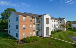an aerial view of an apartment building on a green lawn