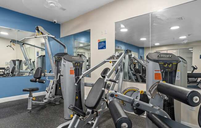 a gym with exercise equipment and mirrors in a building