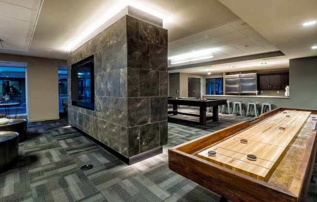 a game room with a shuffleboard table and a pool table