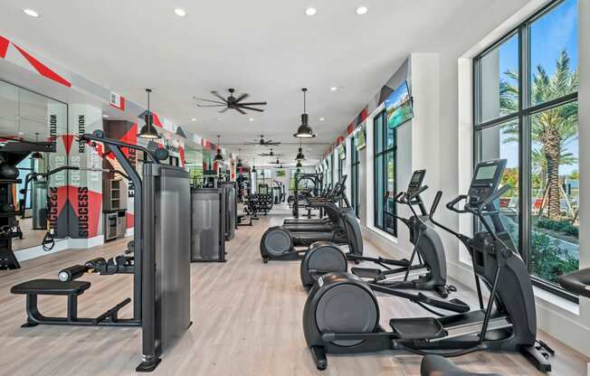 a gym with cardio equipment and windows in a building at Altis Grand Suncoast, Land O' Lakes Florida