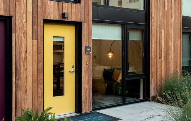 A yellow door is the centerpiece of this modern house entrance.