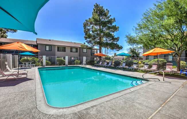 a swimming pool with umbrellas and chairs around it