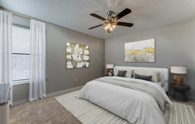 A bedroom with a large bed and a ceiling fan.