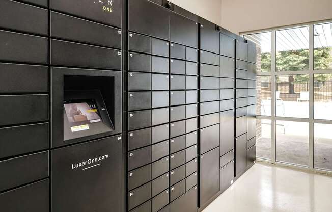 A black wall with a small window and a website address.