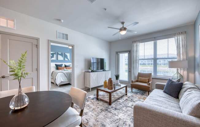 a living room with a couch and a table     and a bedroom