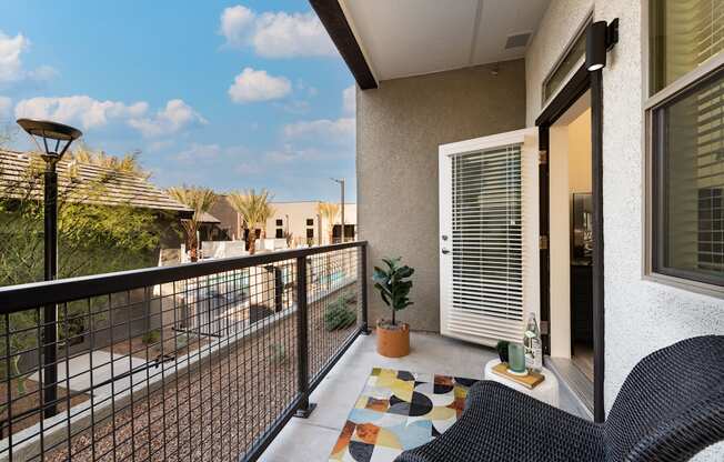 a balcony with a patio and two chairs and a potted plant